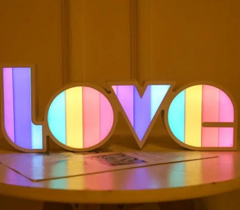 Rainbow style LED LOVE decorative table lamp with plastic shade on a table