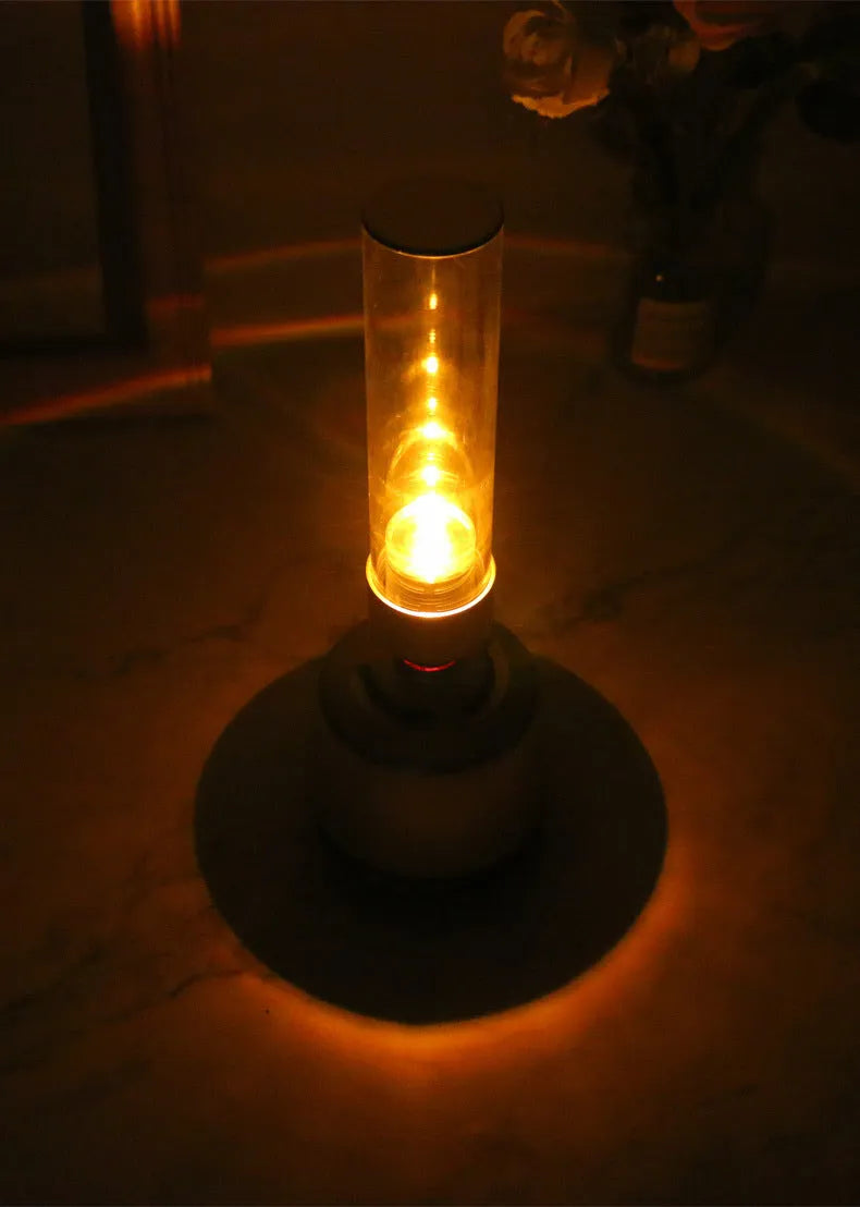 White silver candlelight Bluetooth speaker and night light on a table.