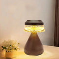 Small black bedside LED lamp with USB charging cable on wooden nightstand