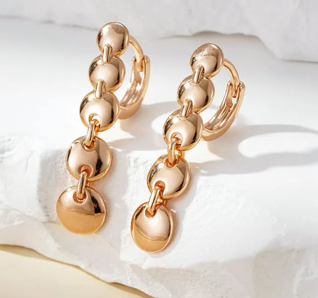 Long round gold retro earrings with woven copper texture, shown as a pair.