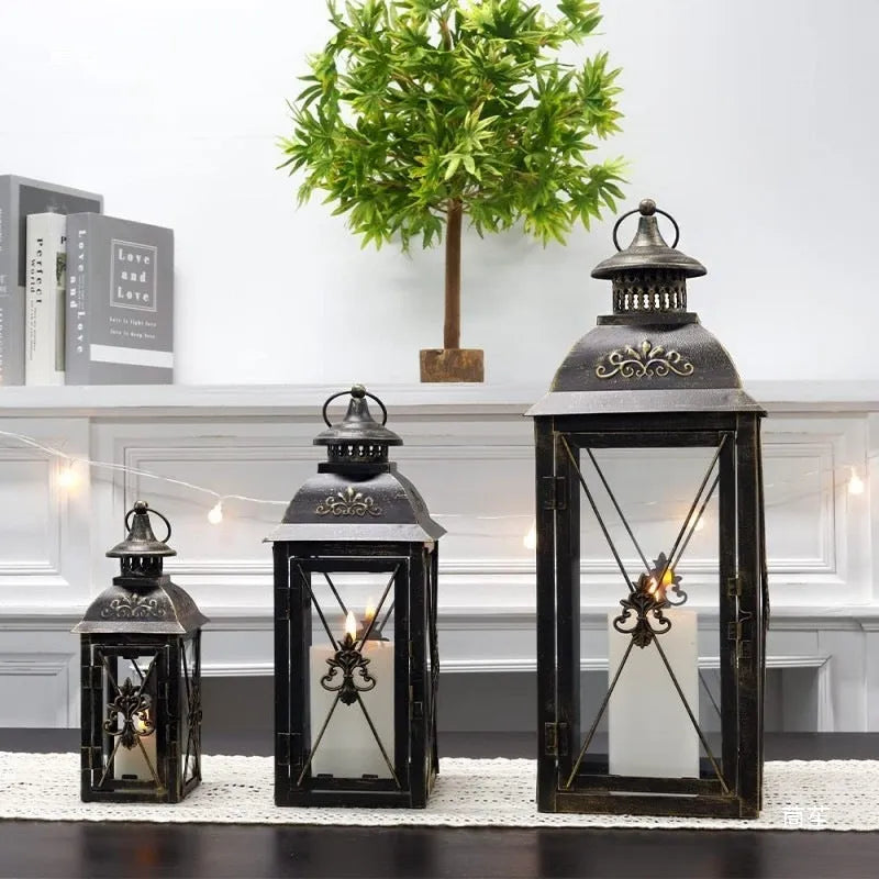 European wrought iron storm lantern with tempered glass in black or white gold finish, shown in small, medium, and large sizes.