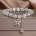 Women's white cat's eye bracelet with flower tassel and safety buckle pendant