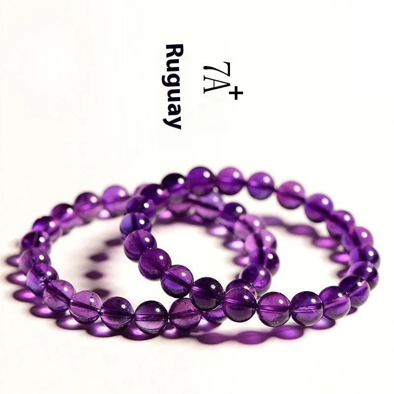 Natural amethyst Uruguay bracelet with scattered polished beads on a white background.