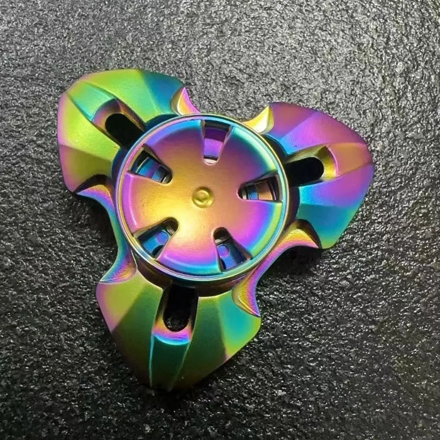Close-up of a metallic alloy rotating fingertip gyro decompression toy on a table.