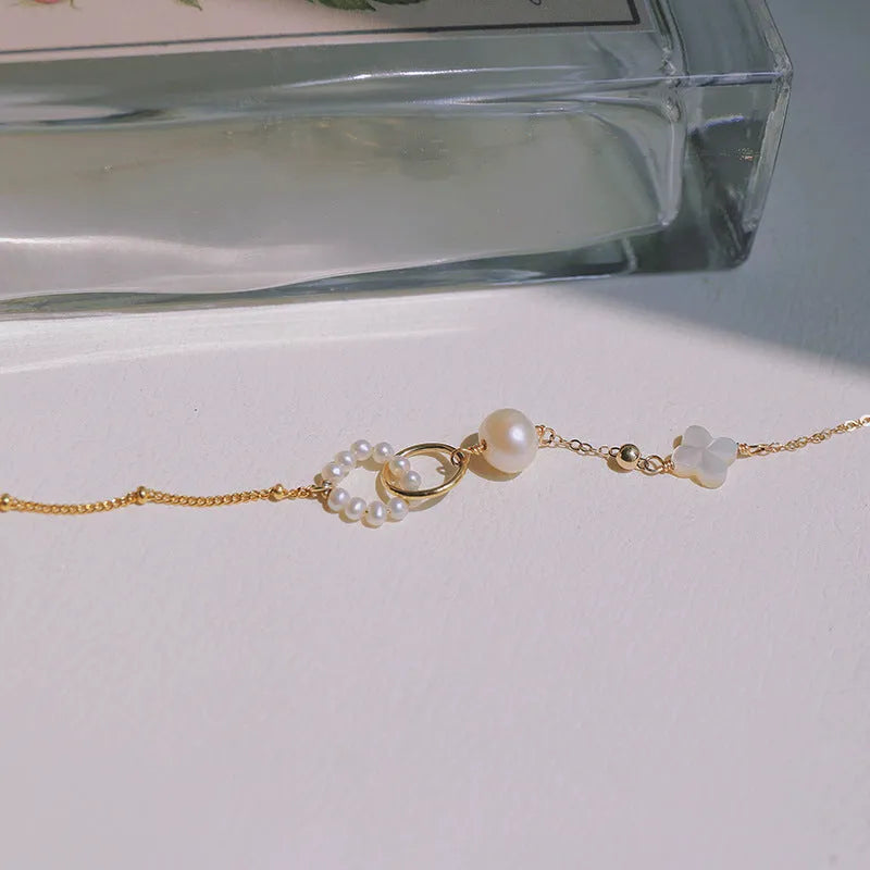 Women's adjustable natural pearl bracelet with gold-plated clasp on white background