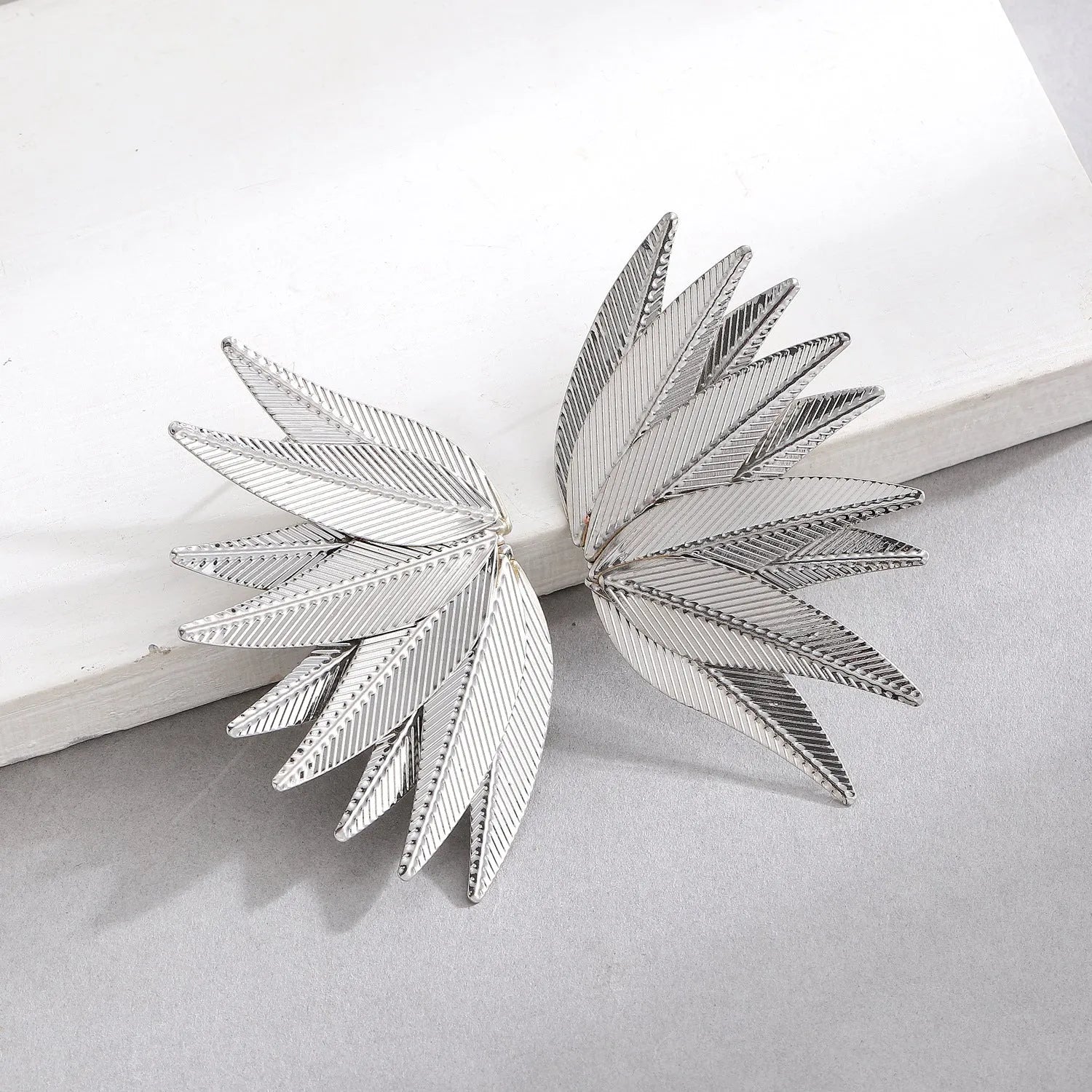 Leaves patch earrings in gold and white colour options with geometric leaf silhouette design