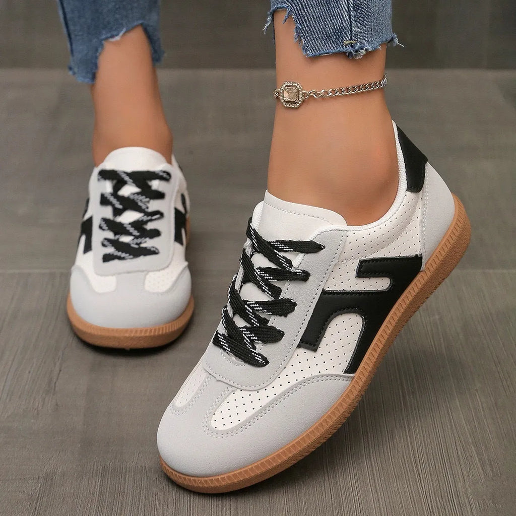 A pair of retro-style low-top lace-up sneakers in a selected colour on a plain background.
