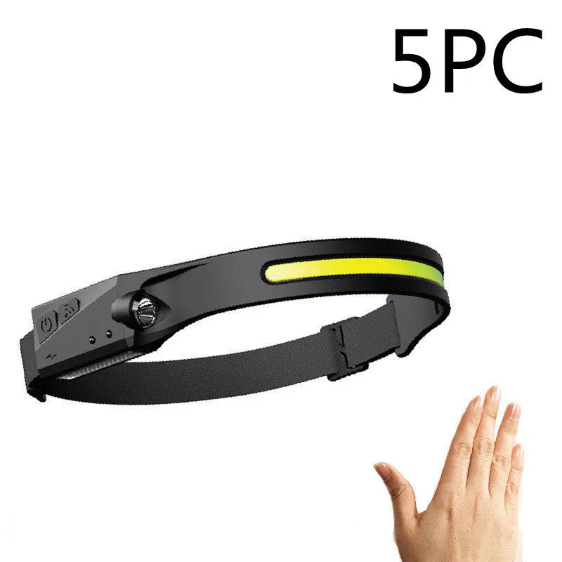 Black silicone USB rechargeable LED headlamp with side wave sensor, showing wide beam and long-range lighting.