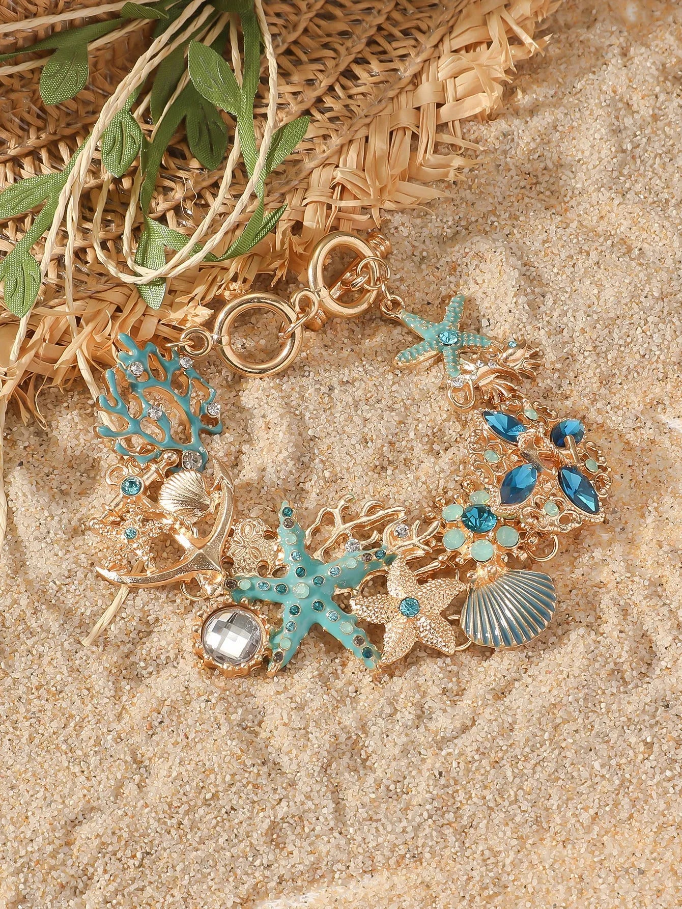 Alloy rhinestone bracelet with boat anchor and starfish design in turquoise, coral red, or coral blue.