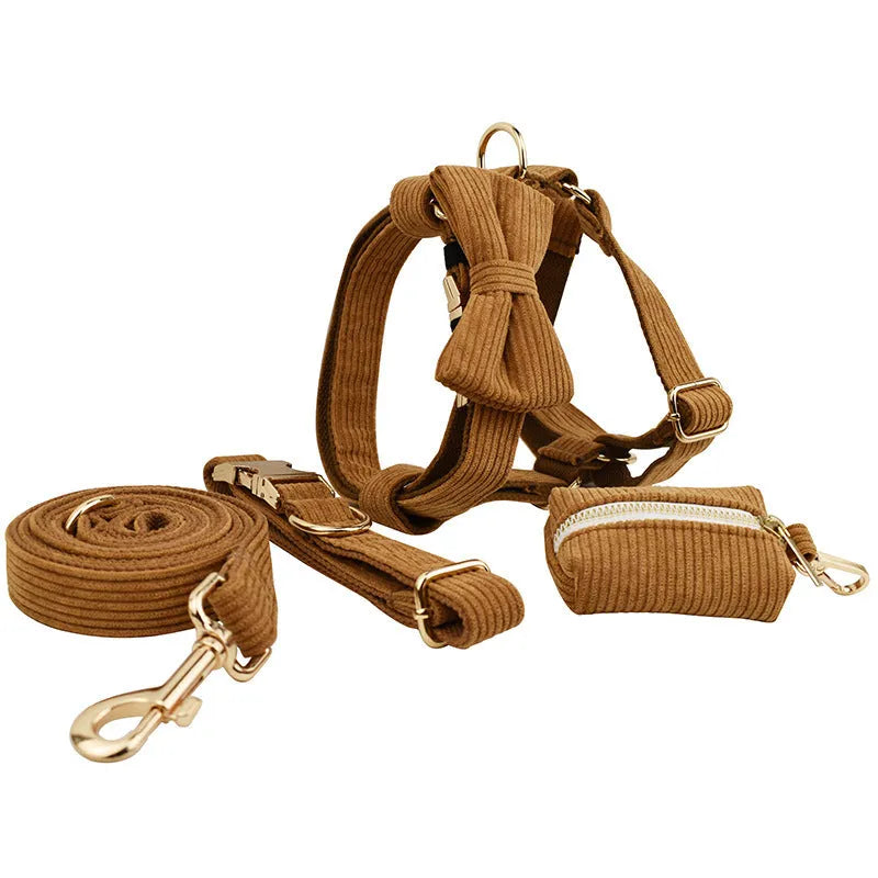 Caramel corduroy pet collar set with ring, rope, bow, vest, and poop bag on a light background
