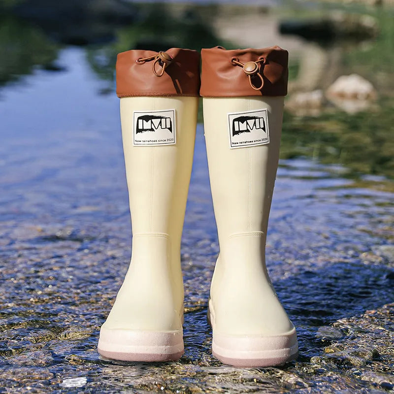 Pair of solid colour high tube PVC rain boots with a low heel on a non-slip sole.
