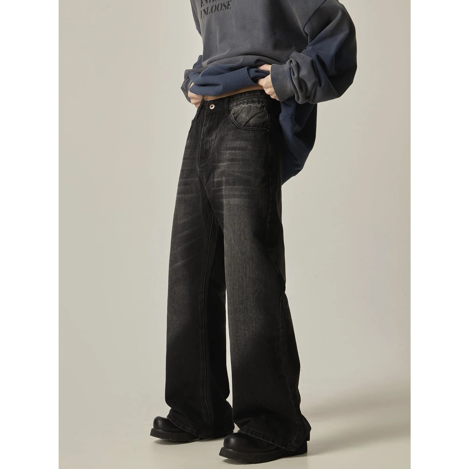 Black loose straight retro jeans with zipper fly closure on plain background
