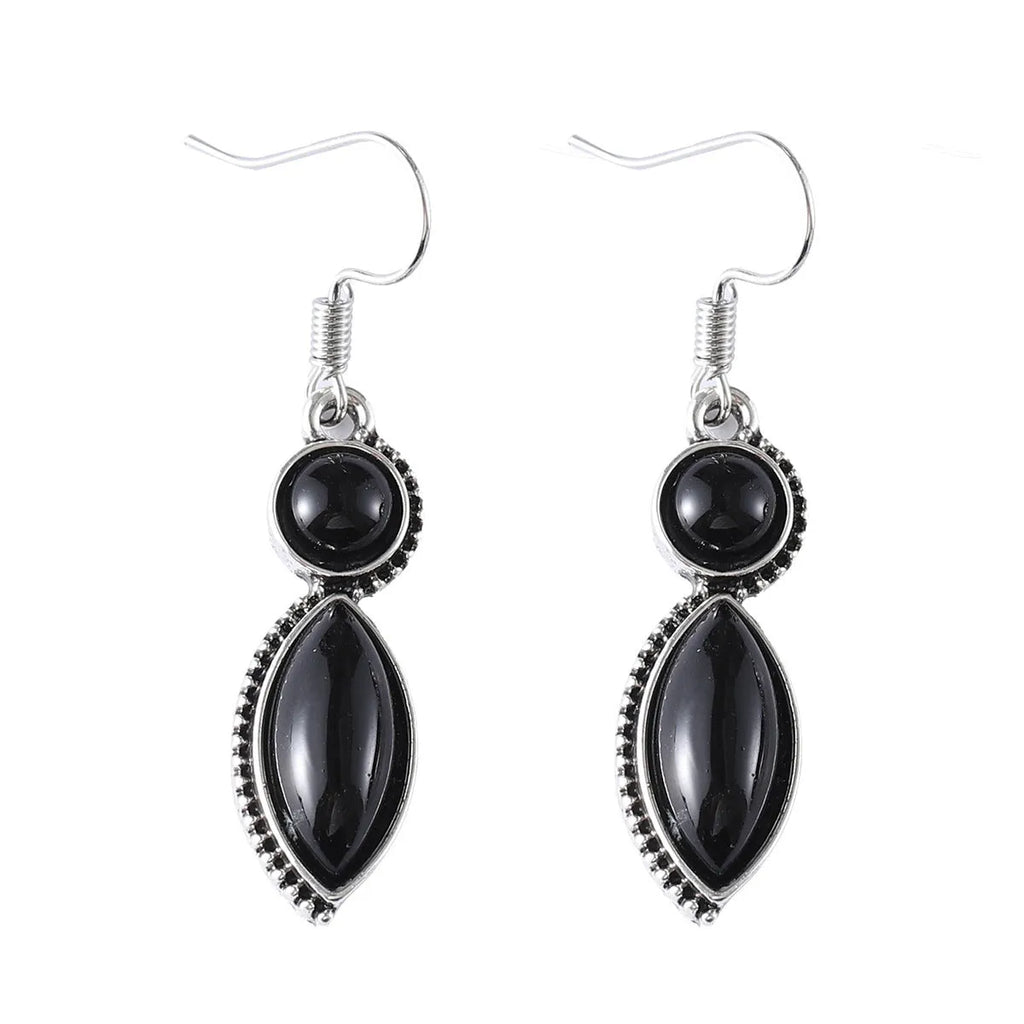 A pair of vintage geometric bohemian pendant earrings in black and purple with round design elements.