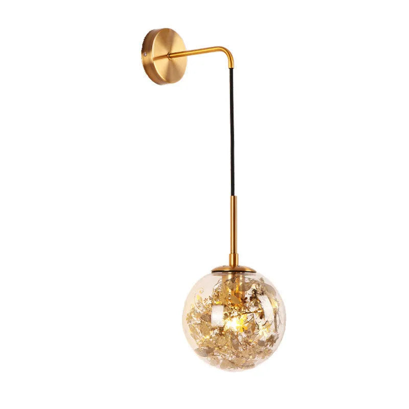 Modern glass wall mounted bedside lamp in golden flower finish on a white wall.
