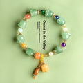 Natural Jinsi Jade bracelet with carved orchid beads on a wrist.