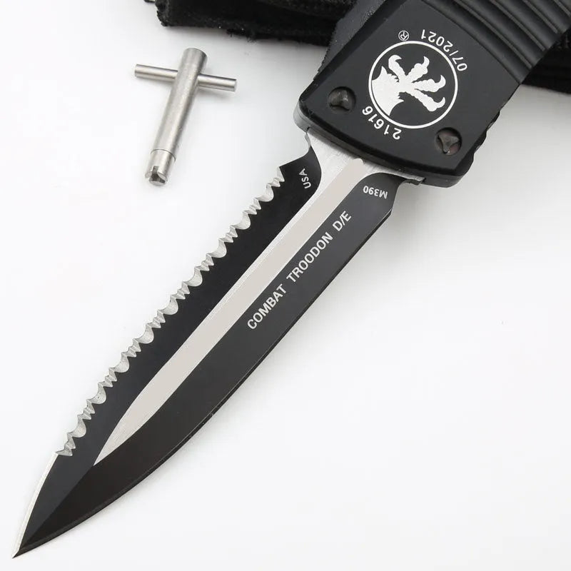 Black folding knife with D2 steel blade and aviation aluminium handle open on a dark surface