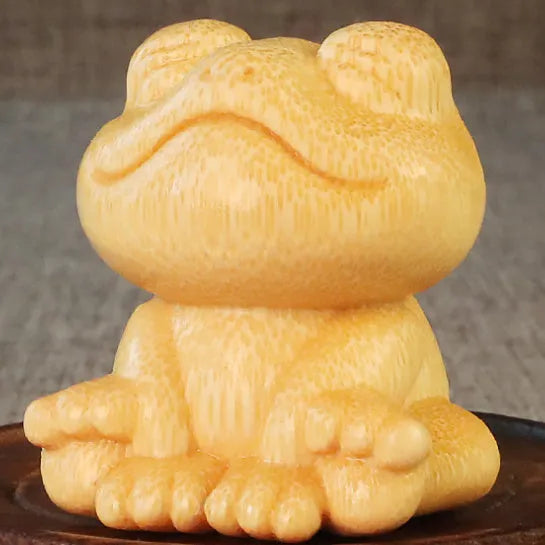 Solid bamboo carved ornament of a smiling cartoon frog, 5cm tall.