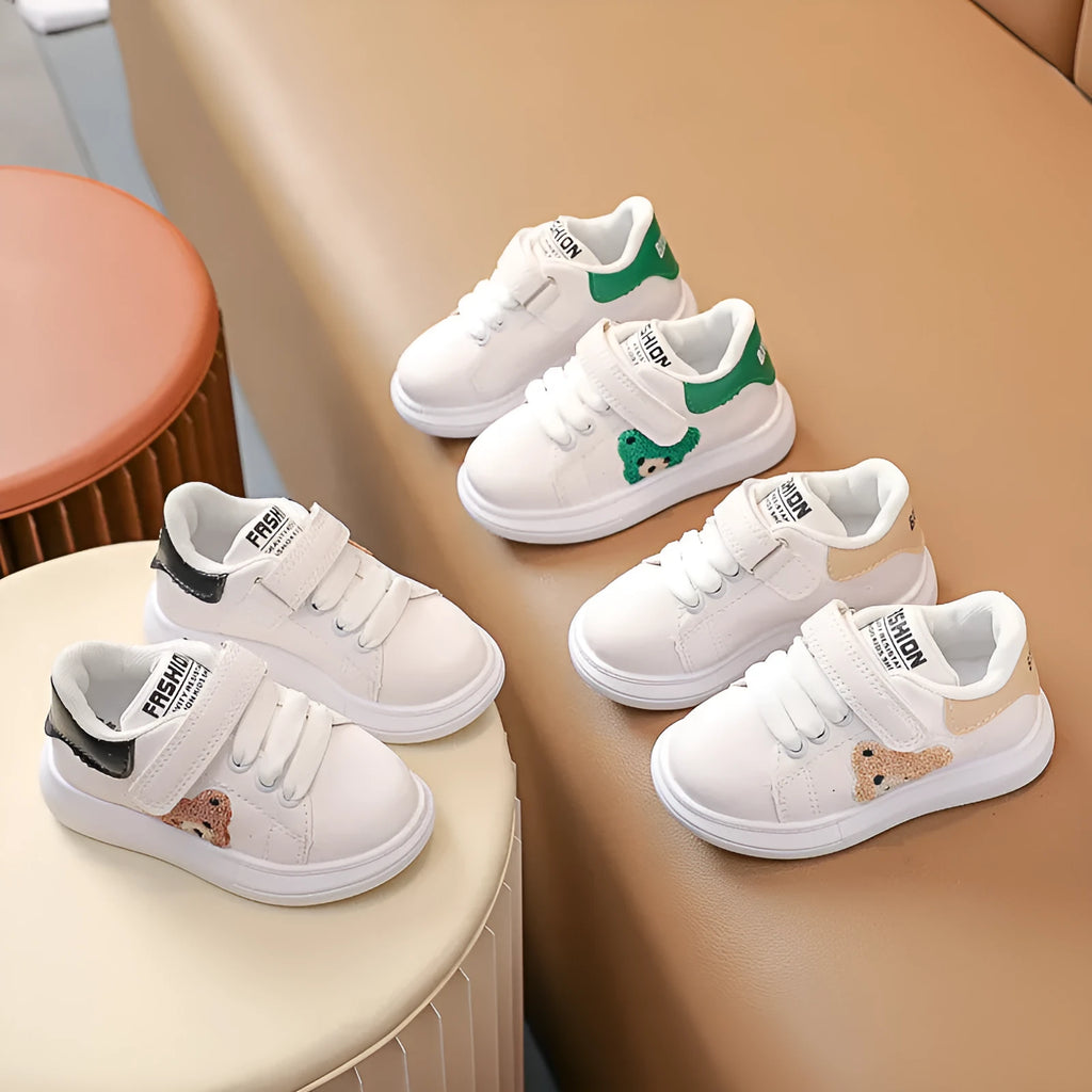 Children's black cartoon bear casual sports shoes with artificial leather upper and rubber sole.