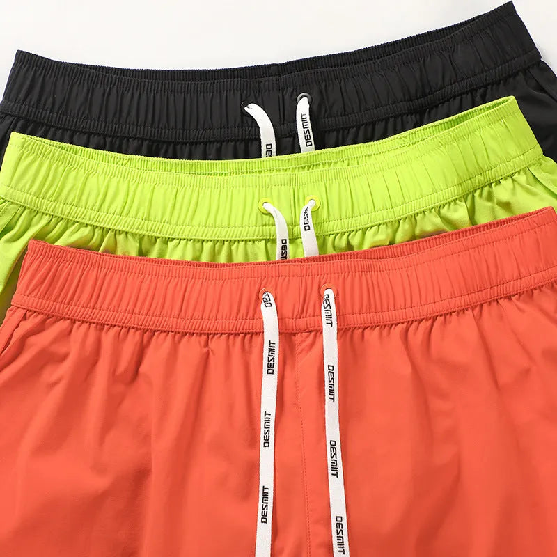 Men's loose fit elastic waist shorts in orange, green, or black for beach and surfing