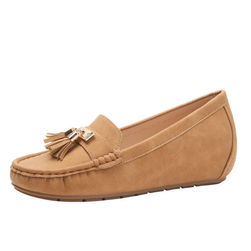 A pair of nude-coloured height-increasing shoe insoles with a round toe and a raised heel section.