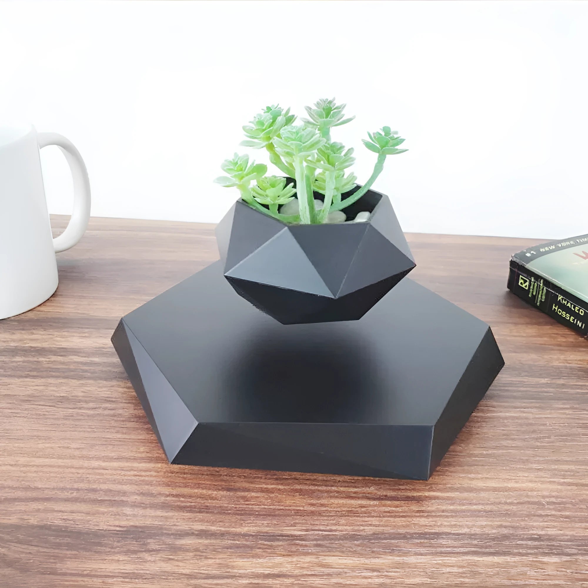 Hexagonal wood grain magnetic levitating flower pot floating above a circular black base on a desk.