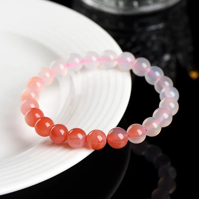 Natural gradient Yanyuan agate bracelet with geometric beads on a wrist, showing colour transition.