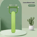 Green plastic and stainless steel dog detangling comb on a grey background.