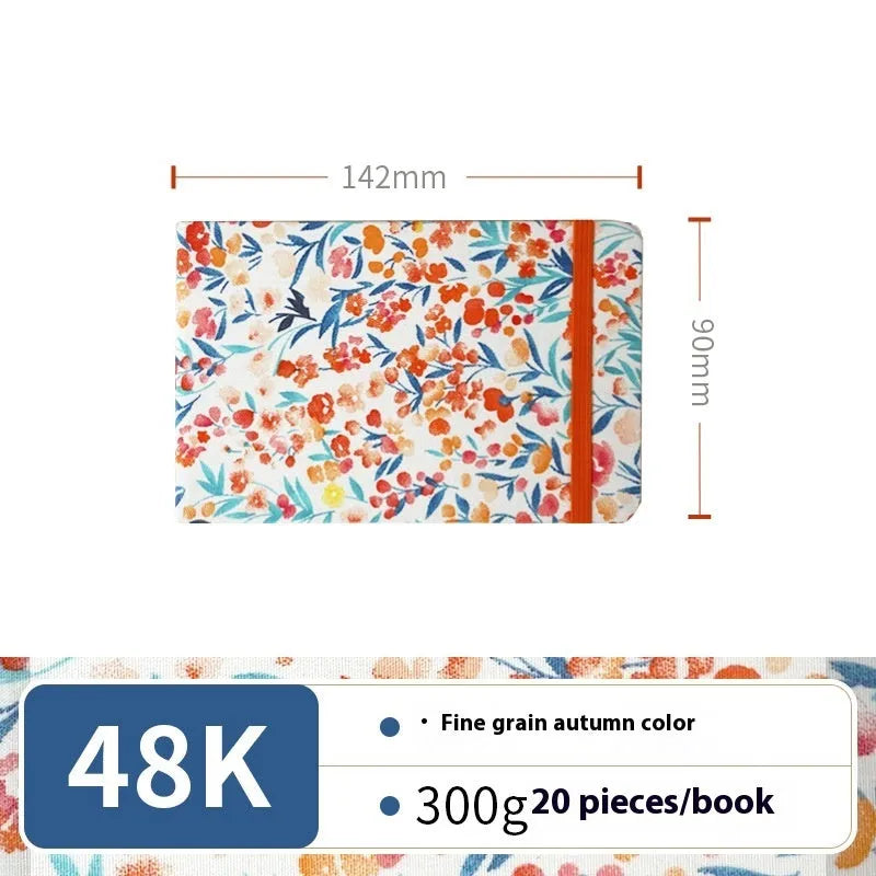 Feiluniao handmade fabric watercolour notebook with illustrated cover, open to show blank paper pages.