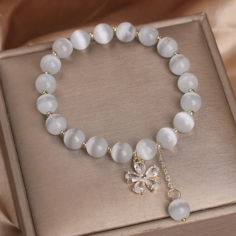 Women's white cat's eye bracelet with flower tassel and safety buckle pendant