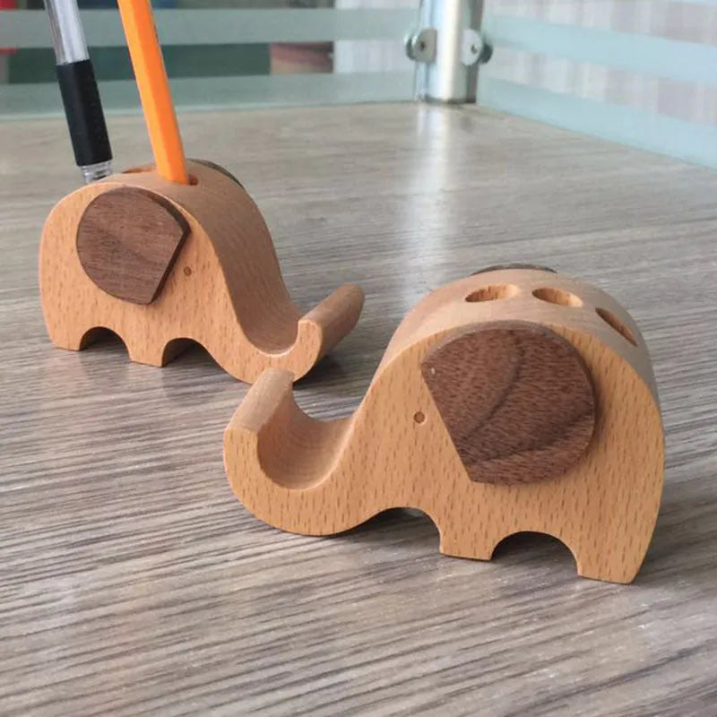 Beech wood and resin lazy bracket mobile phone holder in an animal design style on a desk.