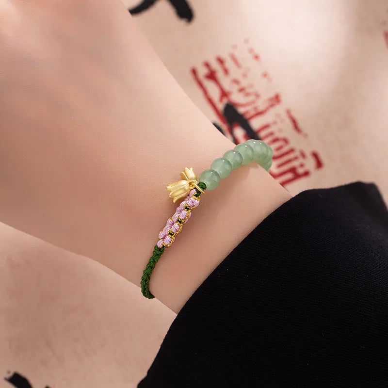 Hand woven red rope bracelet with floral decorative elements in national style design