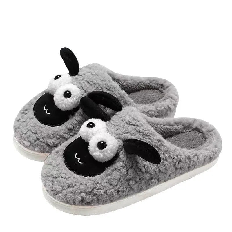 Brown suede slip-on slippers with a sewn PVC sole on a wooden floor.