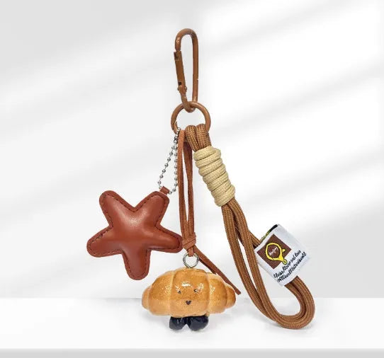 Handmade resin soda bread handbag pendant with baking varnish finish and brown carrying strap.