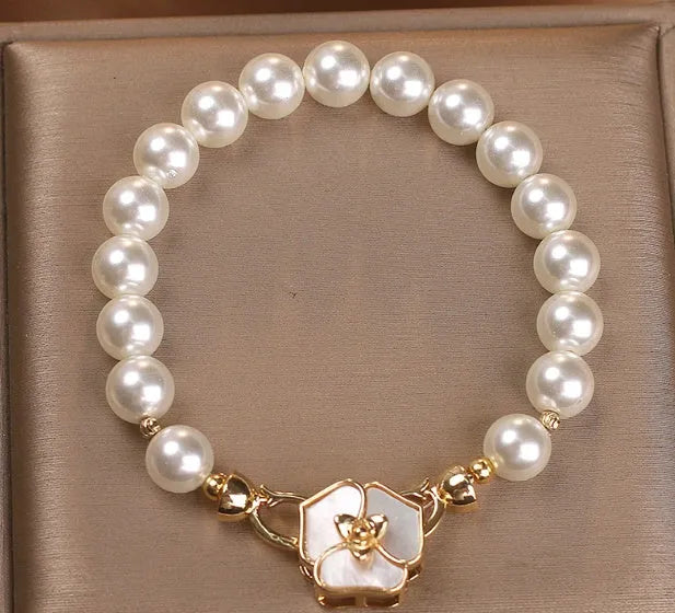 White imitation pearl bracelet with floral French-style design on display for women