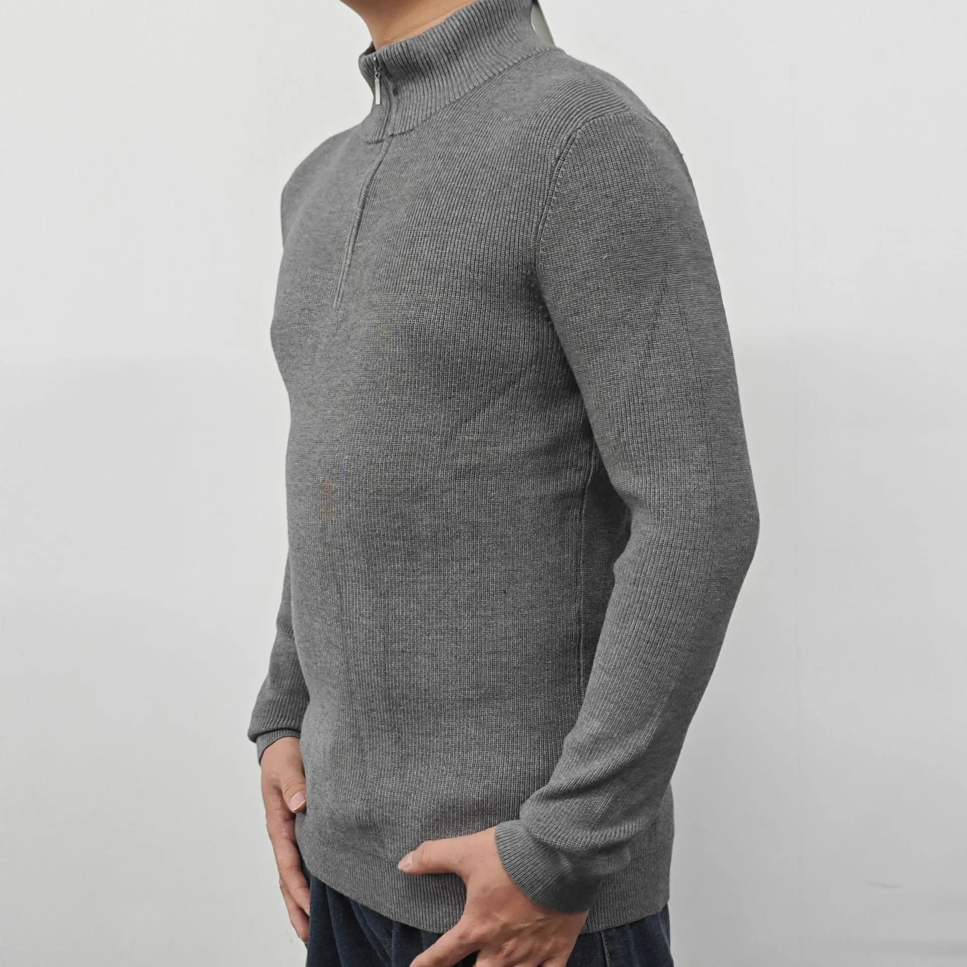 Man wearing a grey half turtleneck zip front sweater, a casual cotton blend pullover.