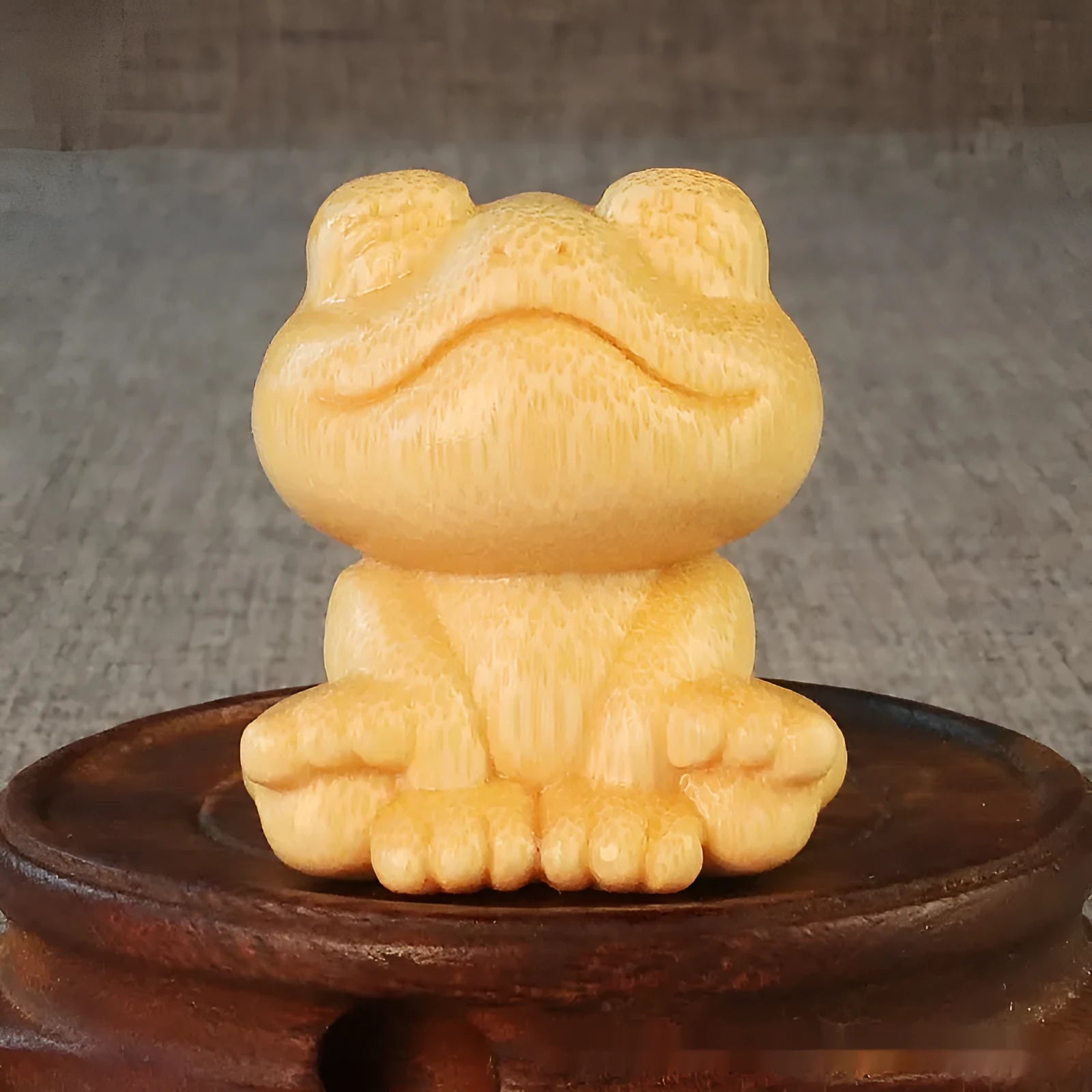 Solid bamboo carved ornament of a smiling cartoon frog, 5cm tall.