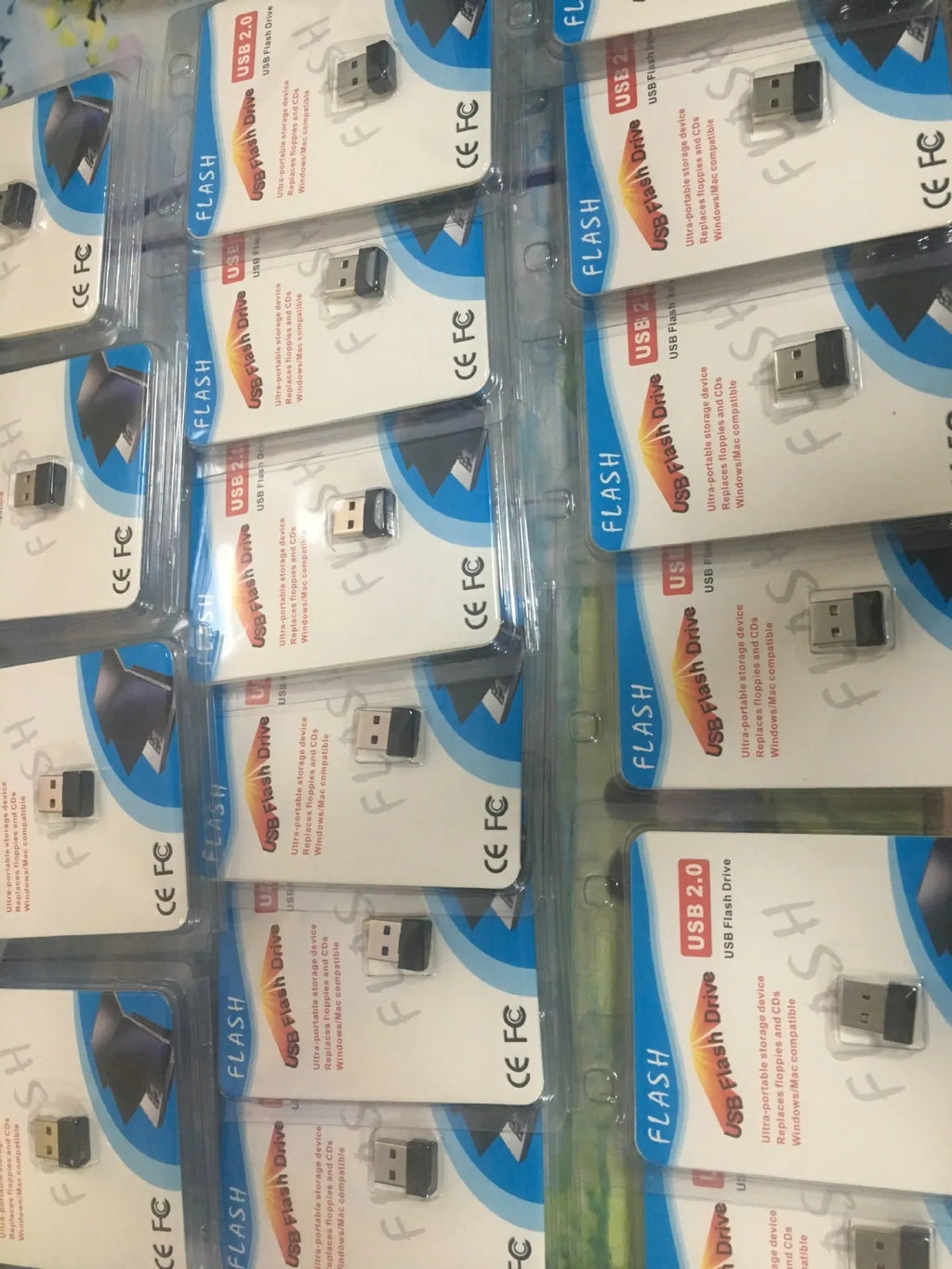 Black plastic USB 2.0 flash drive measuring 2.3 x 1.5 x 0.8 cm with paper card packaging