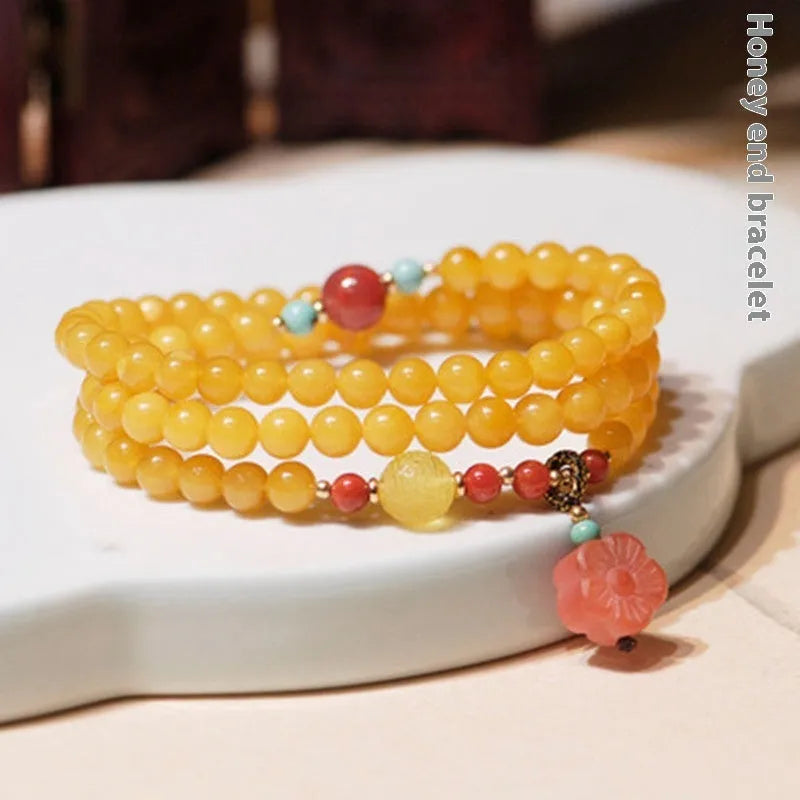 Yellow amber bracelet with 5mm round beads and animal zodiac design on a wrist.