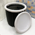 Black inflatable portable ice bath tub with weather lid, shown outdoors.