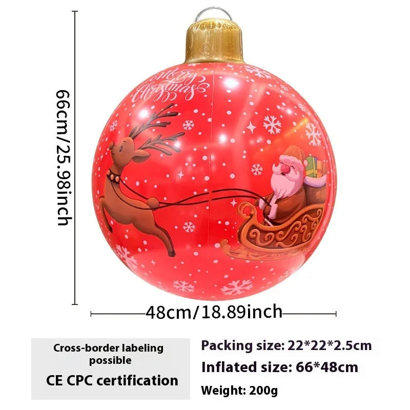 Large red inflatable Christmas ball with flashing lights displayed on a winter garden lawn.