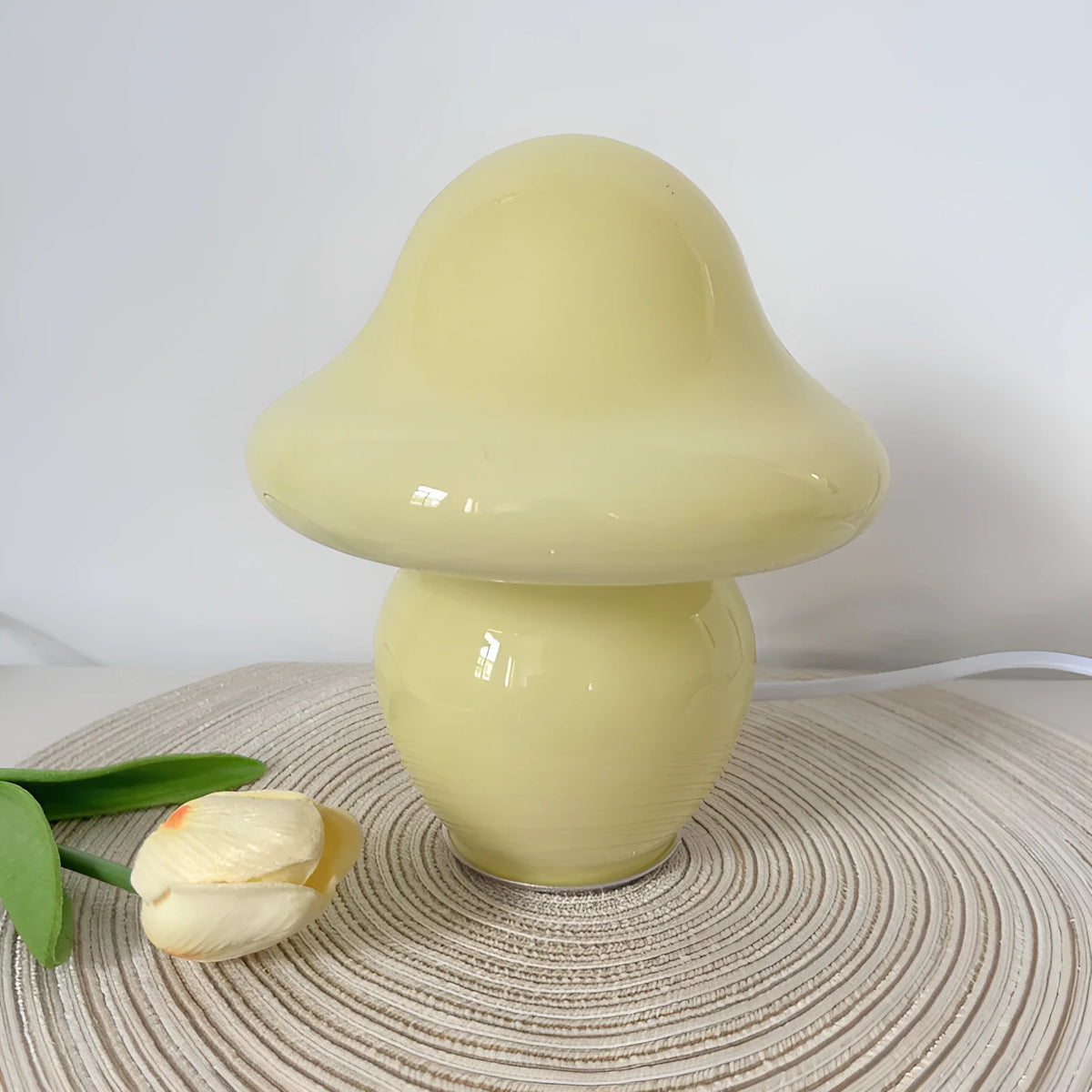 Glass mushroom decorative lamp with three-colour light in orange smooth finish on a wooden table