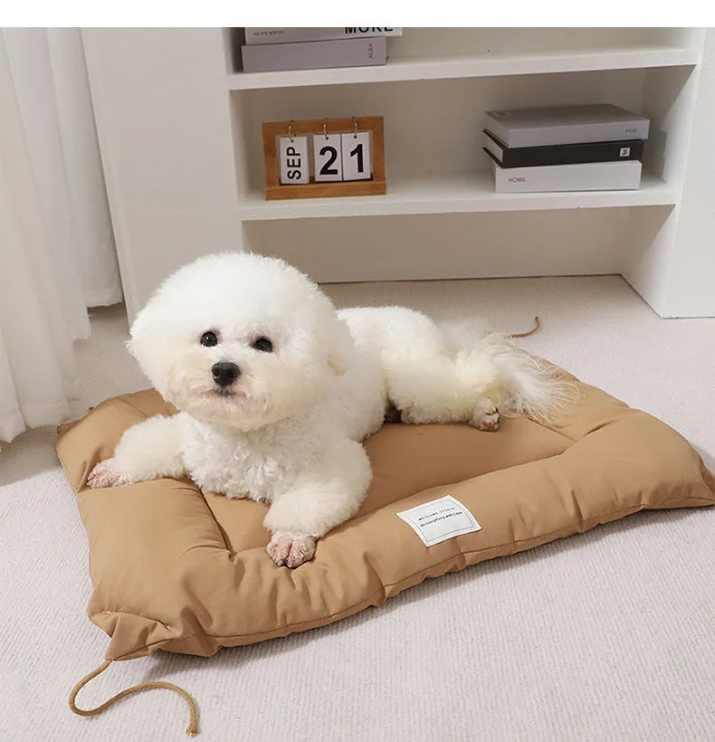 Beige pet cage cushion secured inside a metal dog crate, showing tie straps.
