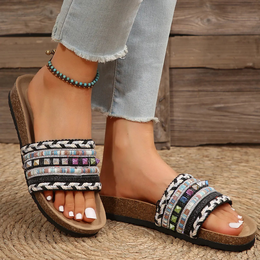 Pair of ethnic style platform slippers with rivet details, featuring linen upper and PVC sole, on a neutral background
