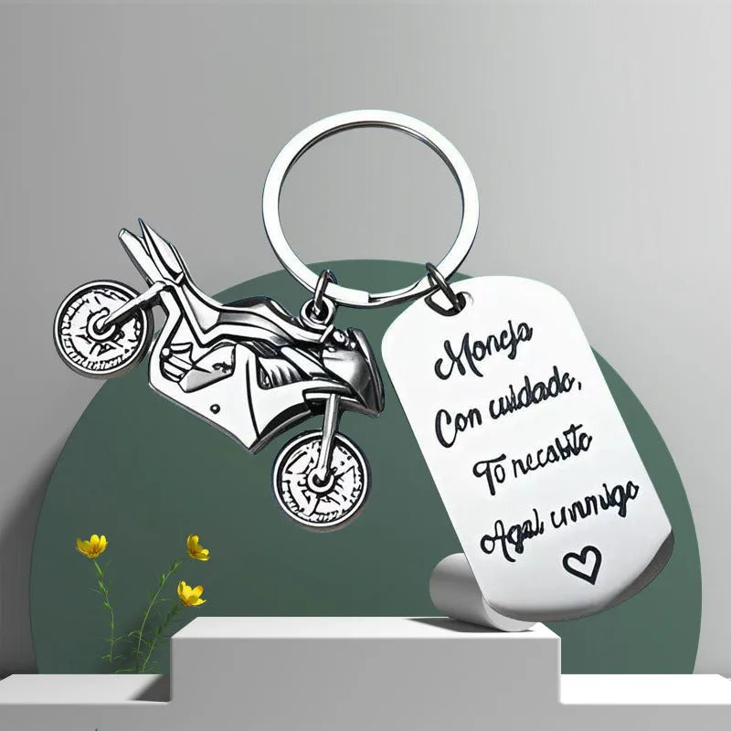 Stainless steel motorcycle-themed keychain on a velvet flannel bag