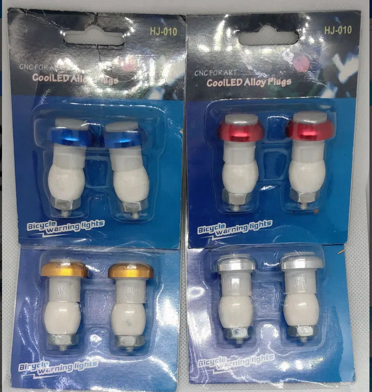 A pair of anodised aluminium bicycle handlebar safety lights in a choice of colours, showing the LED lens and mounting nut.