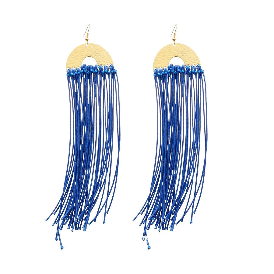 Handmade geometric cloth earrings with a blue resin flower and silver detail on a white background.