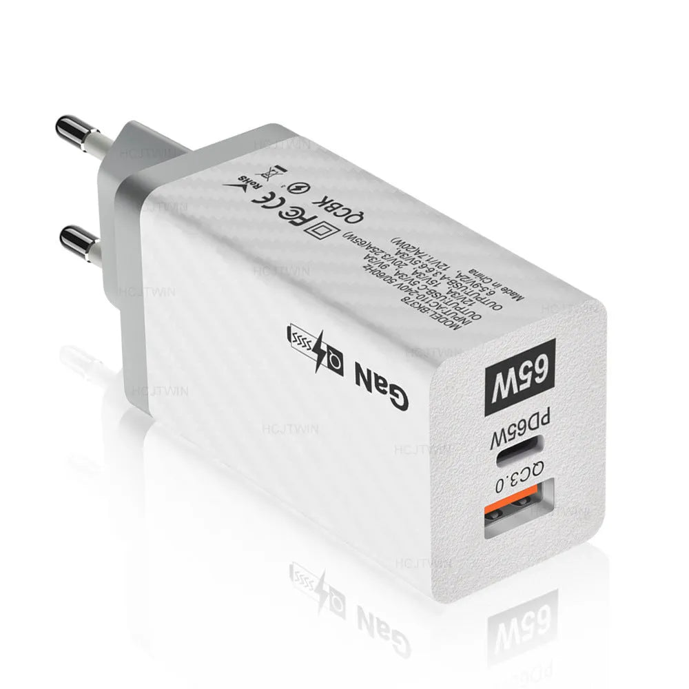 White 65W GaN fast charger with a foldable EU plug next to UK and US plug adaptors.