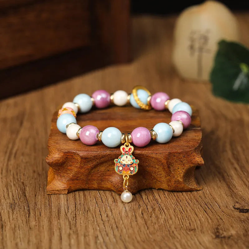 Handmade gray porcelain glazed ceramic lucky rabbit charm on an adjustable elastic bracelet
