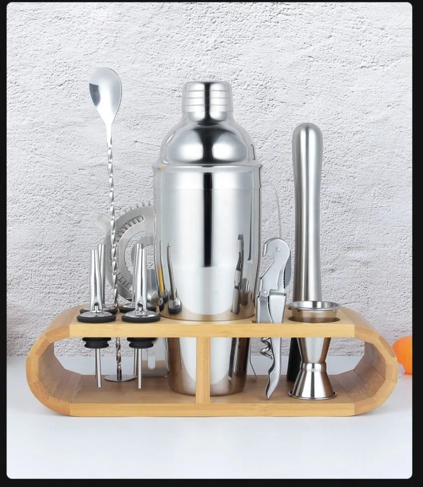 23-piece stainless steel cocktail set with shaker, jiggers, strainer and bar tools on a countertop.