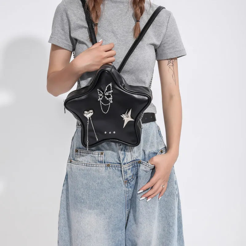 Black street-style PU leather backpack with a metal butterfly pendant and chain trim.